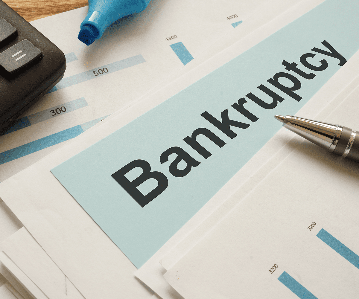 Bankruptcy documents with calculator and pen.