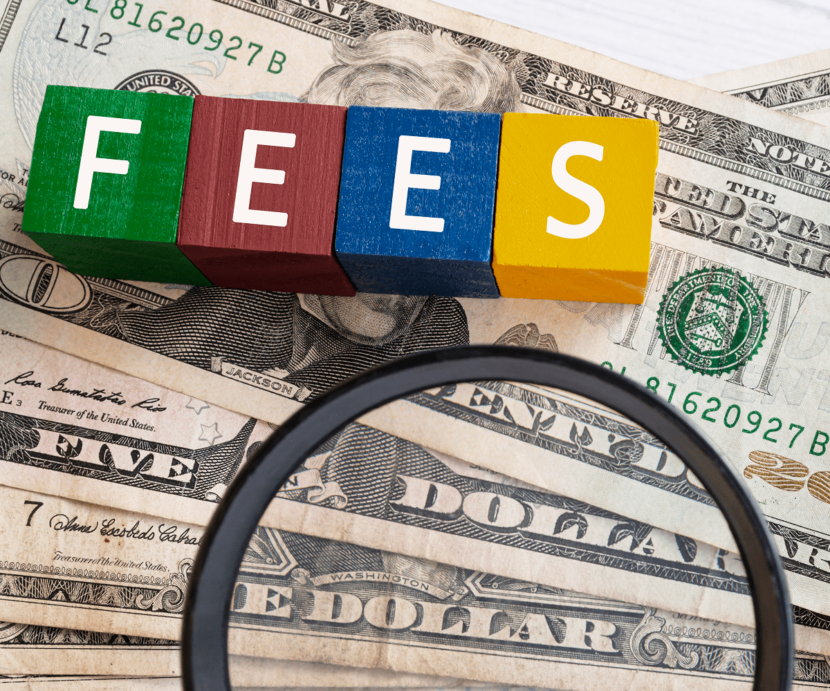 Blocks spelling "fees" on dollar bills.