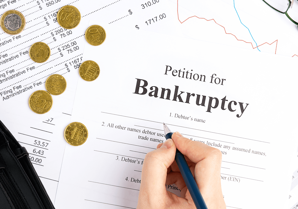 Bankruptcy form with coins and financial documents.