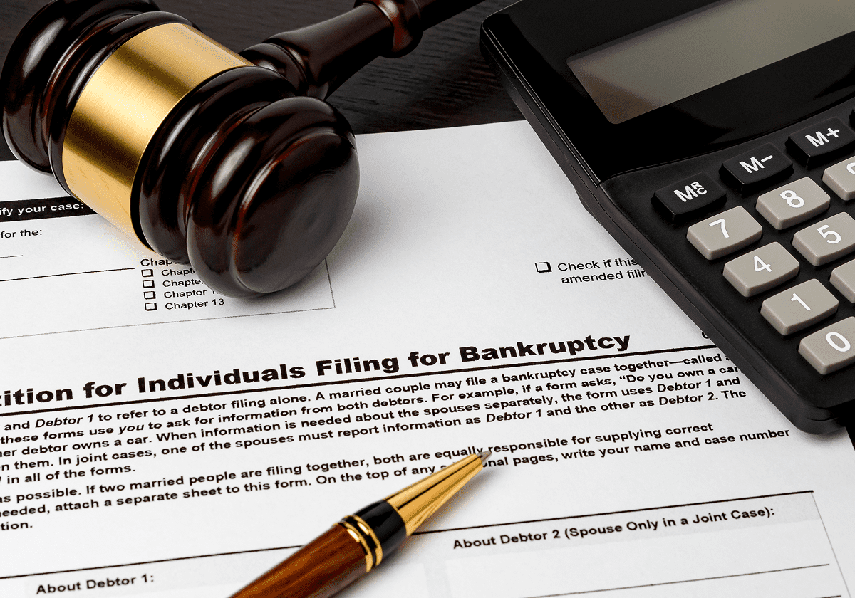 Gavel, calculator, and bankruptcy documents on table.