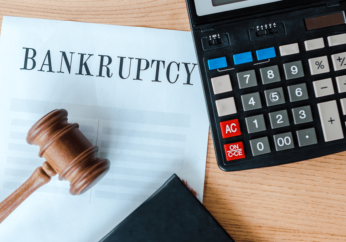 Gavel, calculator, and bankruptcy document on table.