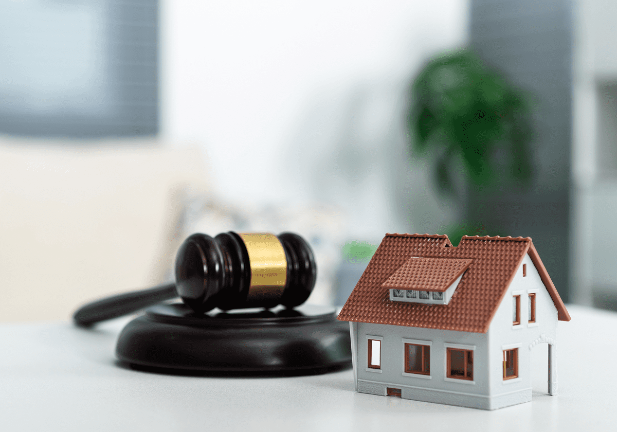 Gavel and house model on table.