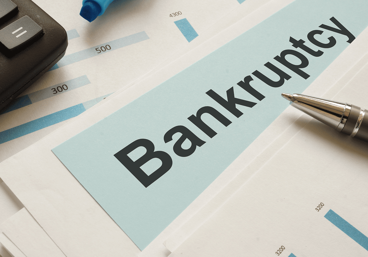 Bankruptcy documents with calculator and pen.