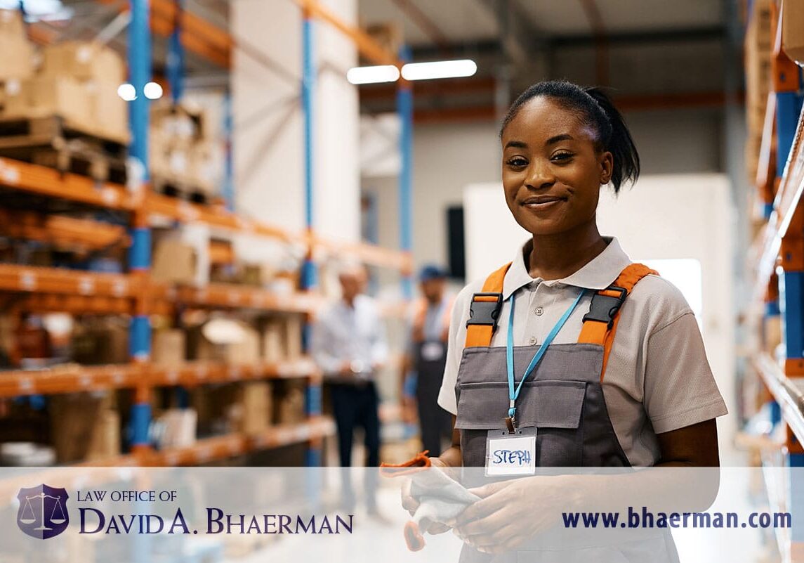 Warehouse worker smiling in uniform and badge.