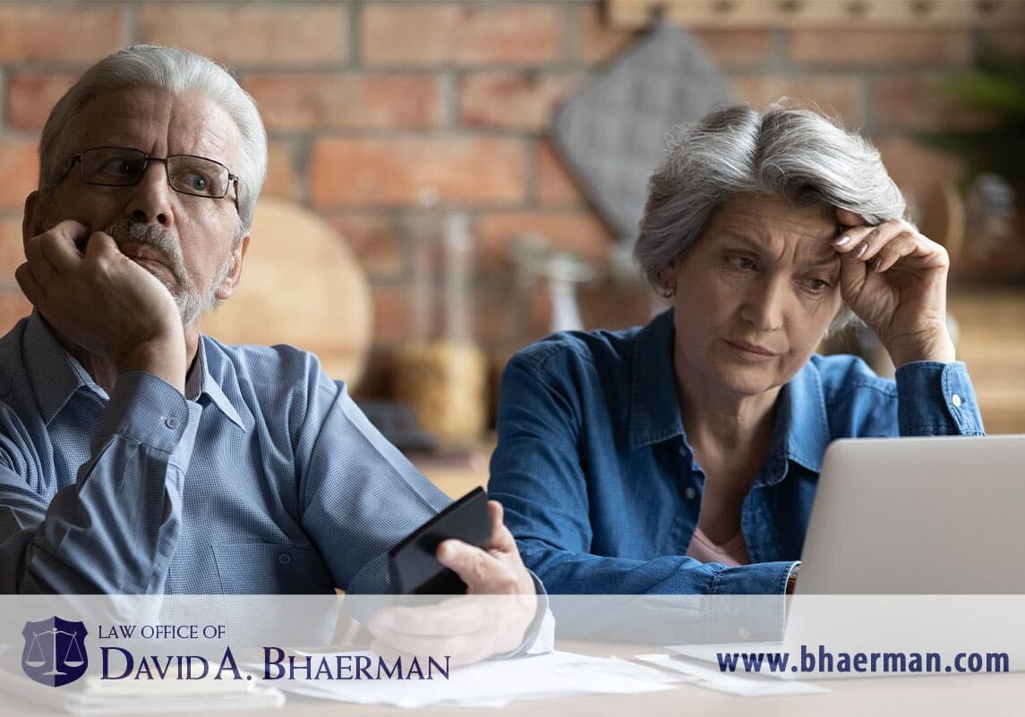 Elderly couple looking worried at laptop.